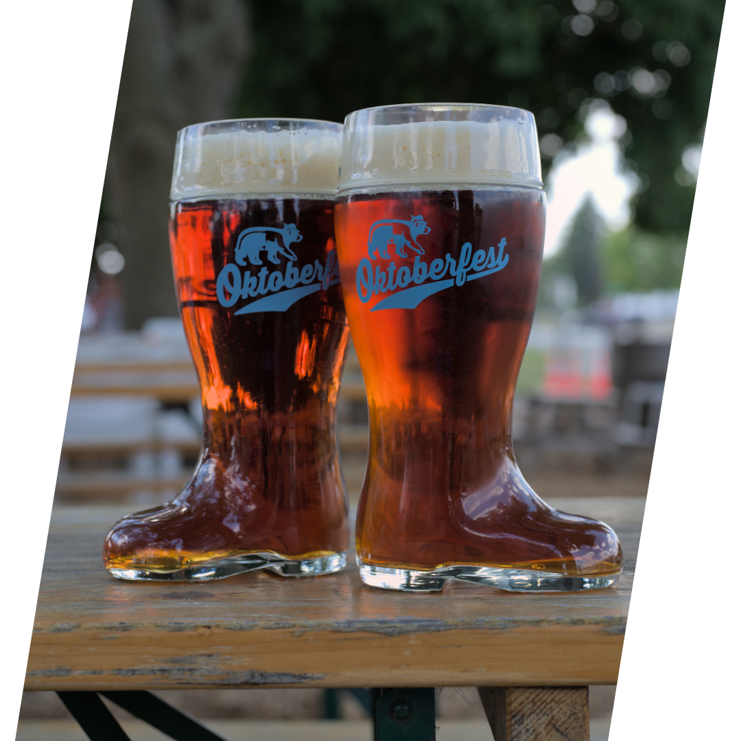 Two glass boot steins filled to the brim with delicious Oktoberfest beer.